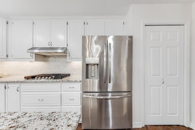 kitchen featuring under cabinet range hood, white cabinetry, appliances with stainless steel finishes, and tasteful backsplash