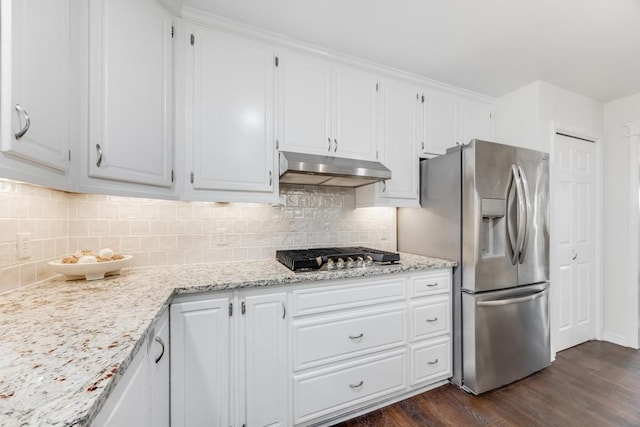 kitchen with dark wood-style floors, decorative backsplash, white cabinets, appliances with stainless steel finishes, and under cabinet range hood