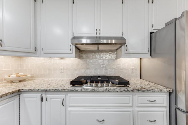 kitchen with white cabinetry, decorative backsplash, appliances with stainless steel finishes, and under cabinet range hood