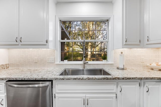 kitchen featuring tasteful backsplash, white cabinets, and stainless steel dishwasher