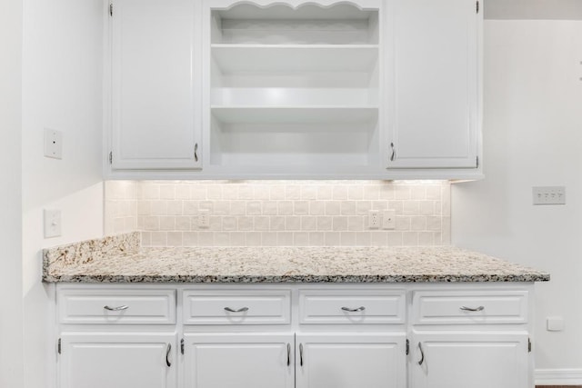 kitchen featuring open shelves, white cabinets, light stone countertops, and tasteful backsplash