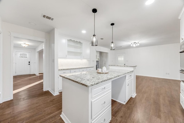 kitchen with visible vents, a kitchen island, dark wood finished floors, open shelves, and white cabinets