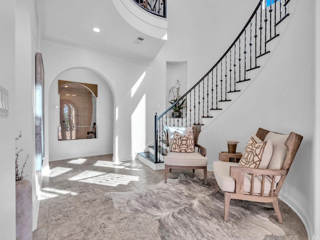 entrance foyer featuring arched walkways, recessed lighting, visible vents, stairs, and marble finish floor