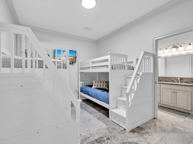 bedroom with ornamental molding, ensuite bath, and a sink