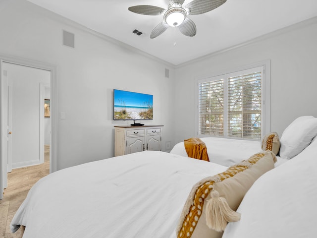 bedroom with ornamental molding, visible vents, and ceiling fan