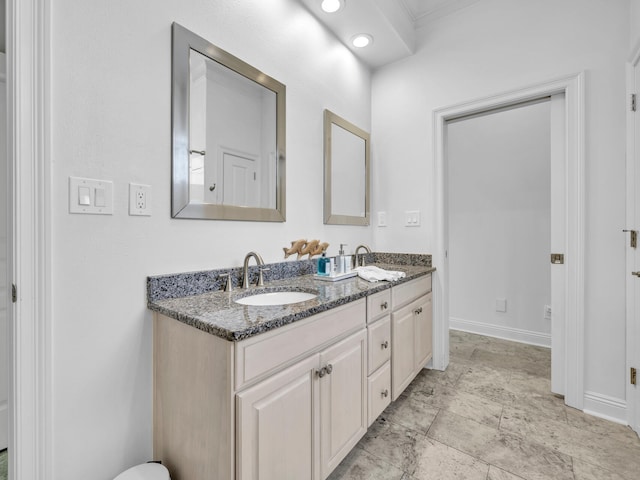 full bathroom with a sink, baseboards, and double vanity