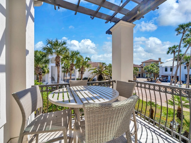 balcony with a residential view, a pergola, and outdoor dining space