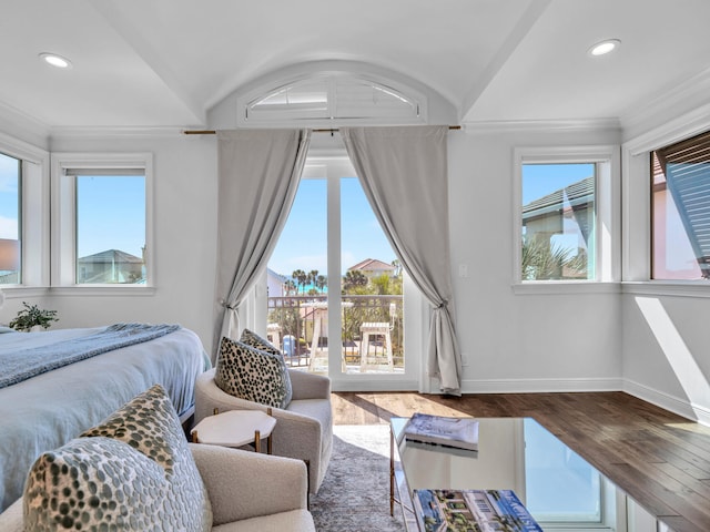 bedroom with access to exterior, vaulted ceiling, baseboards, and wood finished floors