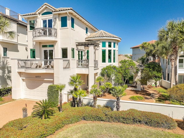 view of front of home featuring a tiled roof, decorative driveway, and stucco siding