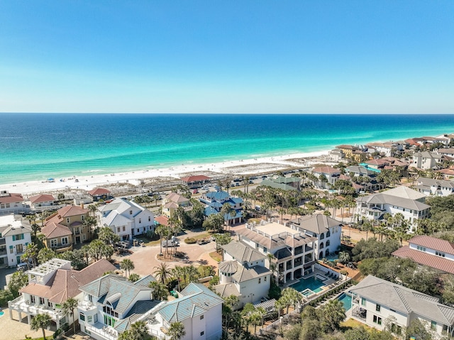 birds eye view of property with a water view and a beach view