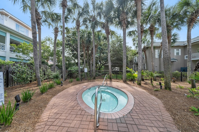 view of pool with fence and a hot tub