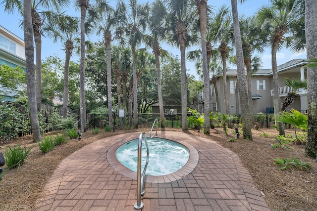 view of swimming pool featuring a hot tub and fence