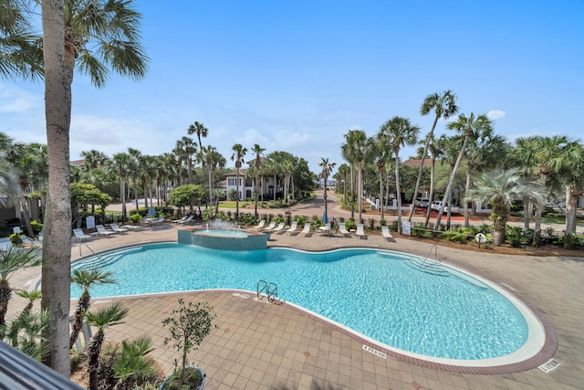 community pool with a patio area and a hot tub