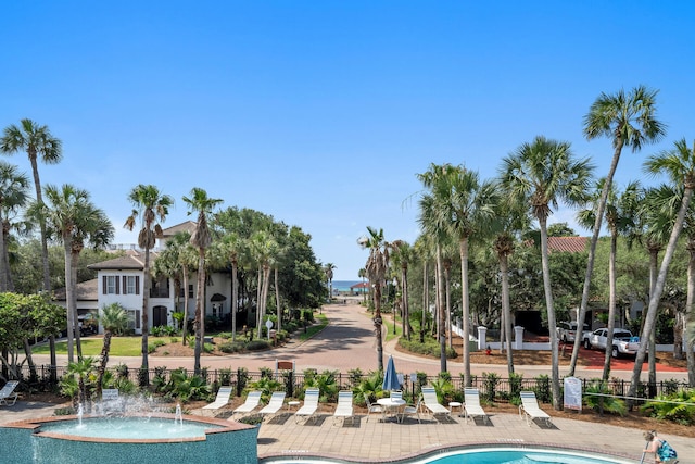 view of home's community with a patio area, a swimming pool, and fence