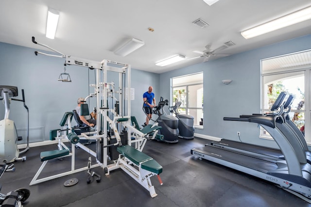 exercise room featuring a ceiling fan, visible vents, and baseboards