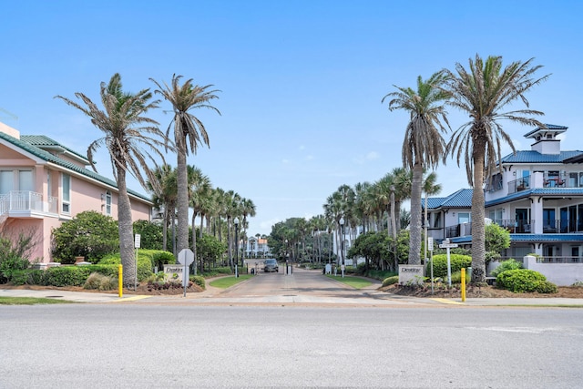 view of road featuring curbs, traffic signs, sidewalks, and a residential view