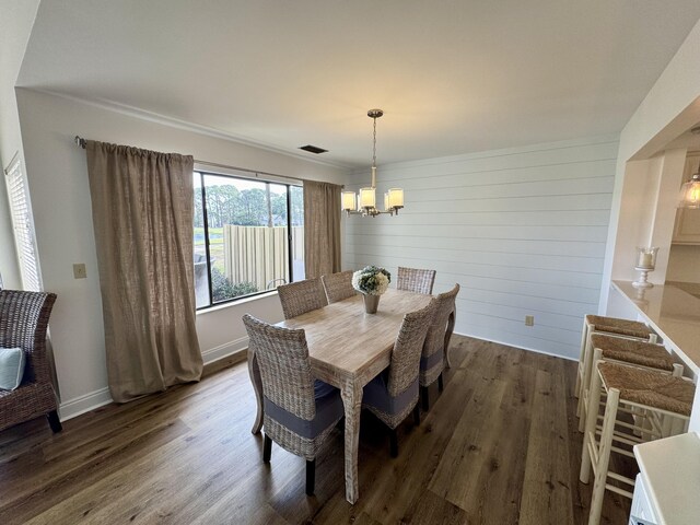 dining area with dark wood finished floors, a chandelier, and baseboards