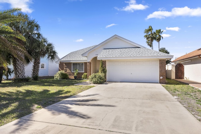 ranch-style home with an attached garage, a front yard, concrete driveway, and brick siding