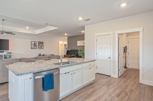 kitchen with visible vents, stainless steel dishwasher, open floor plan, a sink, and an island with sink