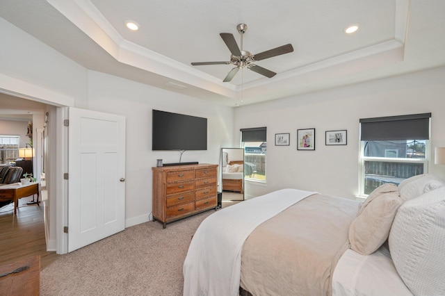 bedroom featuring baseboards, a tray ceiling, crown molding, and recessed lighting