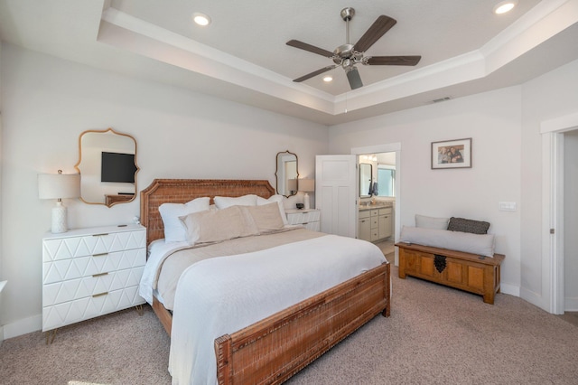 bedroom featuring a tray ceiling, light carpet, and baseboards