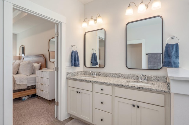 ensuite bathroom featuring double vanity, ensuite bath, and a sink