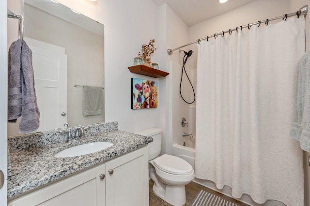 bathroom with toilet, shower / bath combo with shower curtain, wood finished floors, and vanity