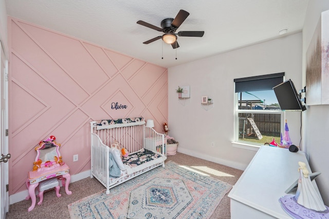 bedroom with a crib, carpet, and baseboards