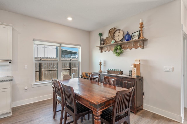 dining room with light wood finished floors, recessed lighting, and baseboards