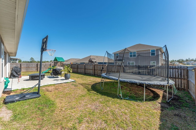 view of yard with a trampoline, a patio area, a playground, and a fenced backyard