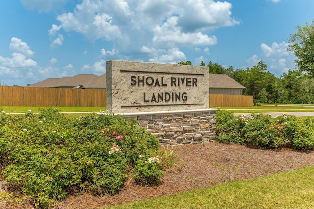 community / neighborhood sign featuring fence