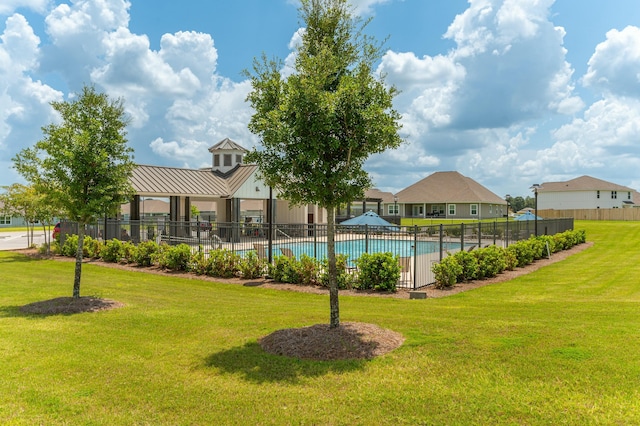 community pool featuring fence and a yard