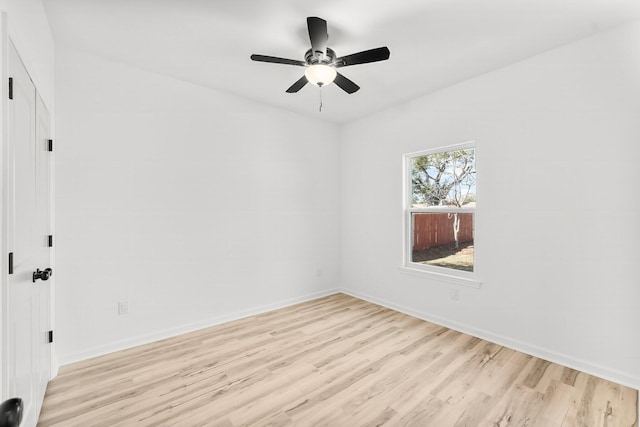 spare room with light wood-style floors, ceiling fan, and baseboards