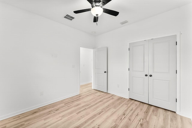 unfurnished bedroom with light wood-style floors, a ceiling fan, visible vents, and a closet