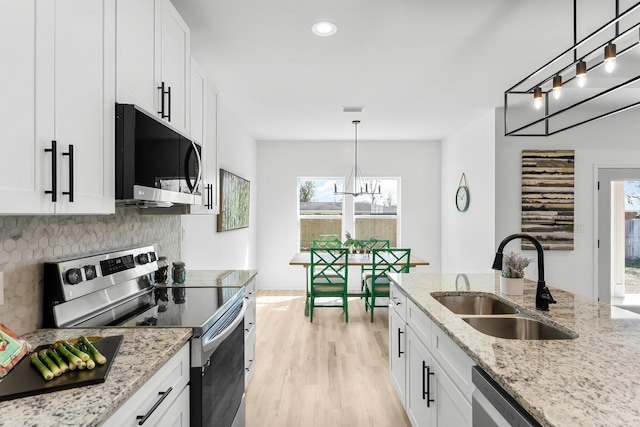 kitchen with stainless steel appliances, backsplash, light wood-style floors, white cabinets, and a sink