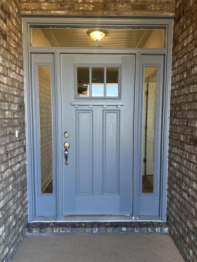 property entrance featuring brick siding