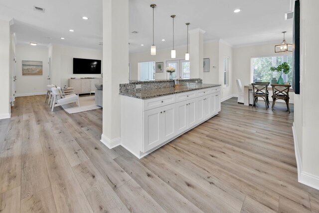 38 Basswood Dr, Santa Rosa Beach, FL 32459 - kitchen with light wood-style floors, dark stone countertops, visible vents, and white cabinetry