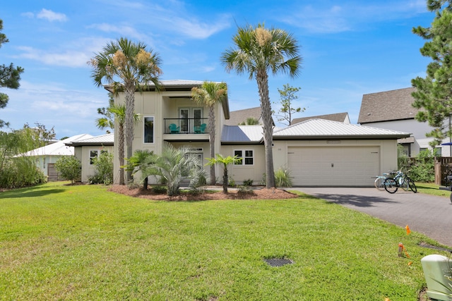 38 Basswood Dr, Santa Rosa Beach, FL 32459 - view of front facade featuring an attached garage, metal roof, a balcony, driveway, and a front lawn