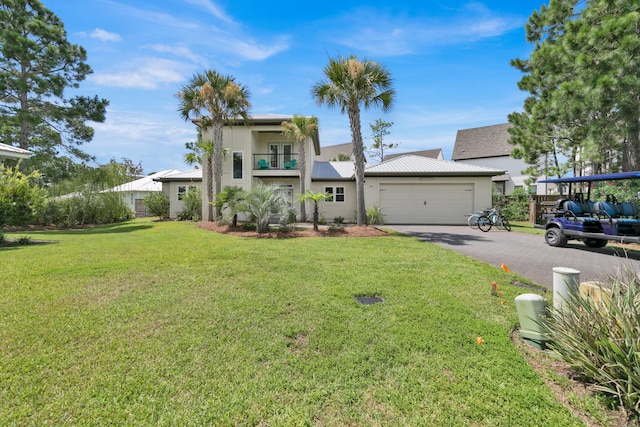 view of front of property with metal roof, a balcony, a garage, driveway, and a front lawn