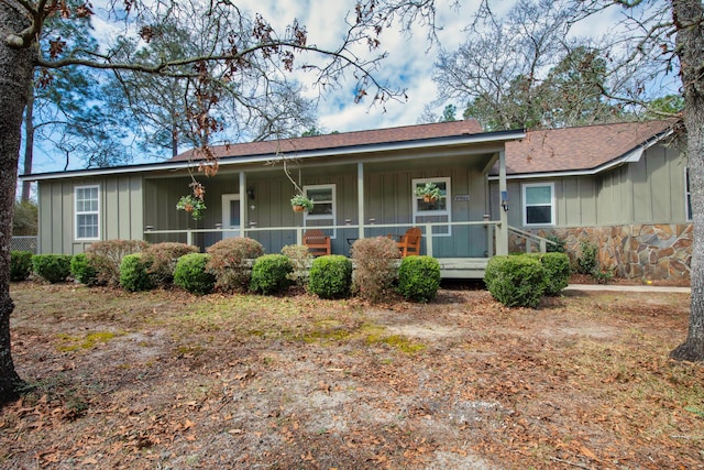 ranch-style home featuring a porch, stone siding, and board and batten siding