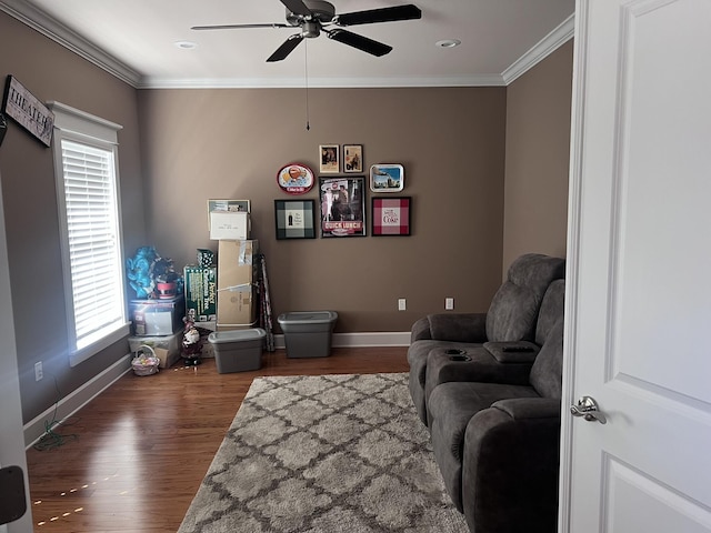 living area featuring baseboards, wood finished floors, ceiling fan, and ornamental molding