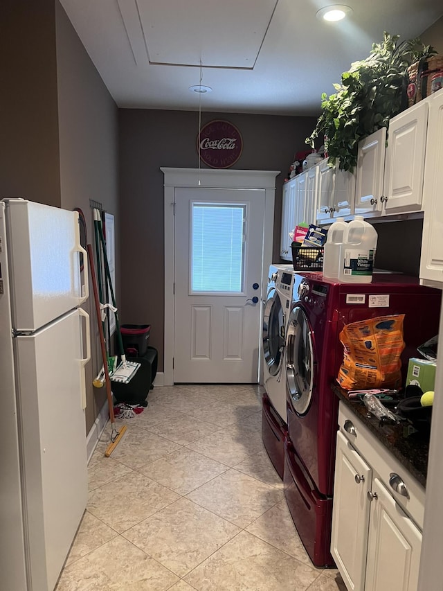 washroom featuring attic access, light tile patterned floors, and washing machine and dryer