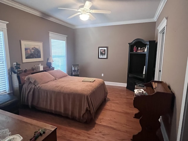 bedroom featuring ceiling fan, baseboards, wood finished floors, and crown molding