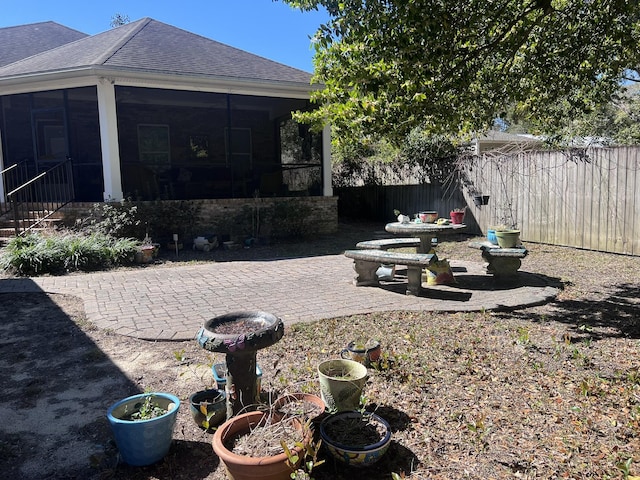 view of yard with a patio area, a fenced backyard, and a sunroom