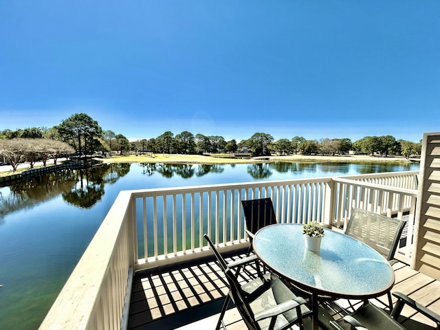 balcony featuring outdoor dining space and a water view