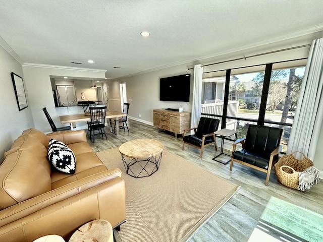 living area featuring ornamental molding, recessed lighting, light wood-style flooring, and baseboards