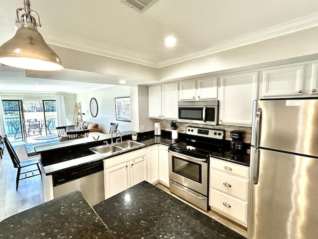 kitchen with visible vents, appliances with stainless steel finishes, ornamental molding, white cabinets, and a sink