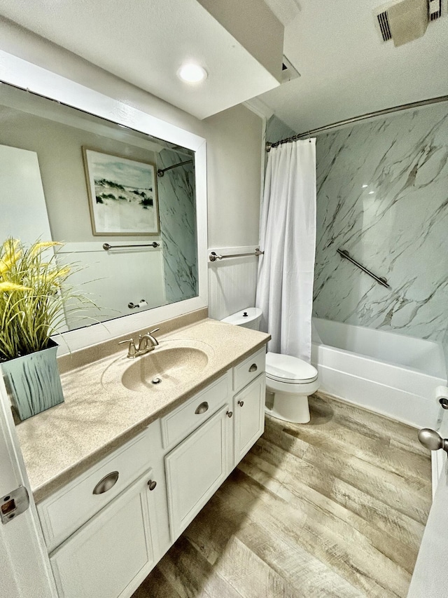 bathroom featuring toilet, wood finished floors, visible vents, vanity, and shower / bath combination with curtain