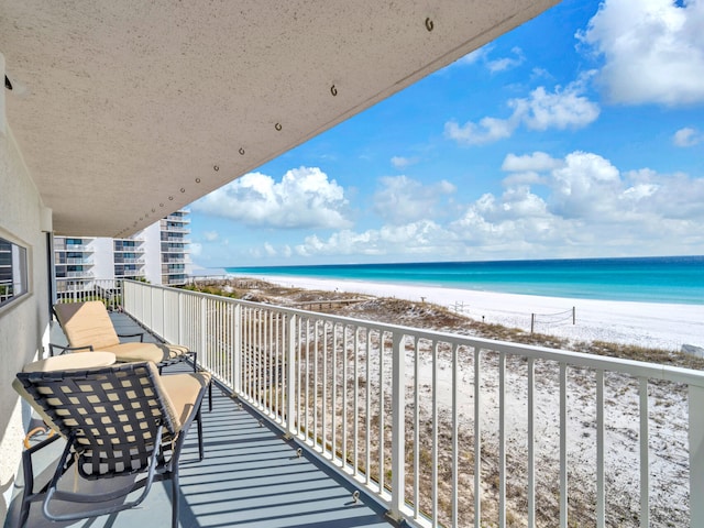 balcony with a water view and a beach view