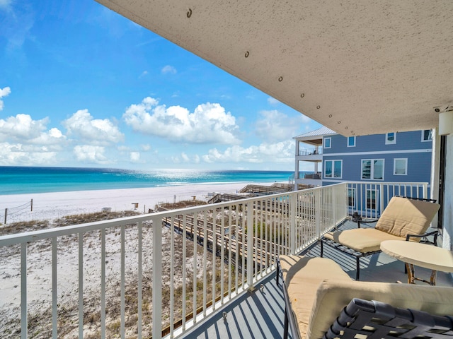 balcony featuring a water view and a view of the beach